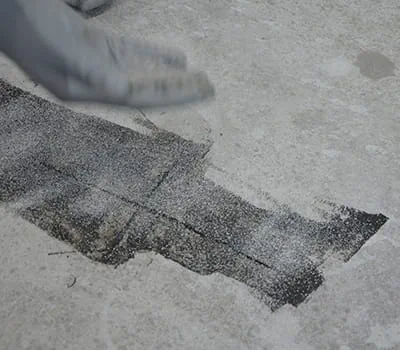 Esparcir arena de cuarzo en la resina de moldeo recién aplicada.