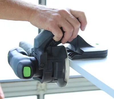 Guiado de la lijadora a lo largo del canto